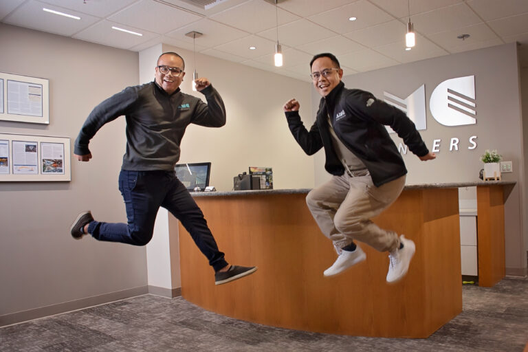 Two AMC employees jumping and smiling