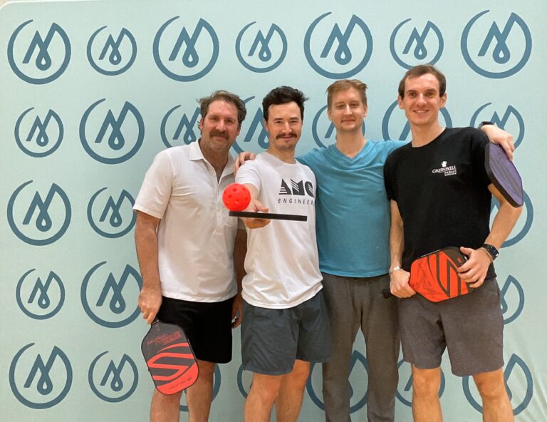 Four men playing pickleball