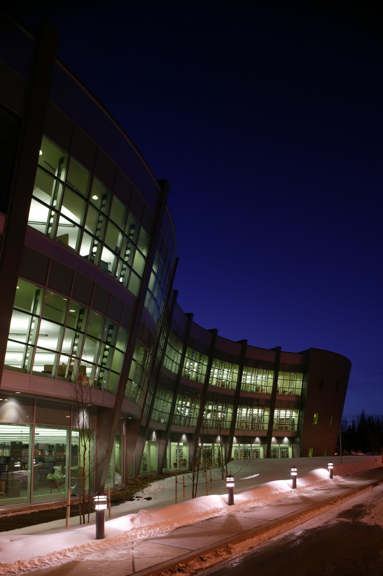 Wavy decorative exterior of building lit up at night