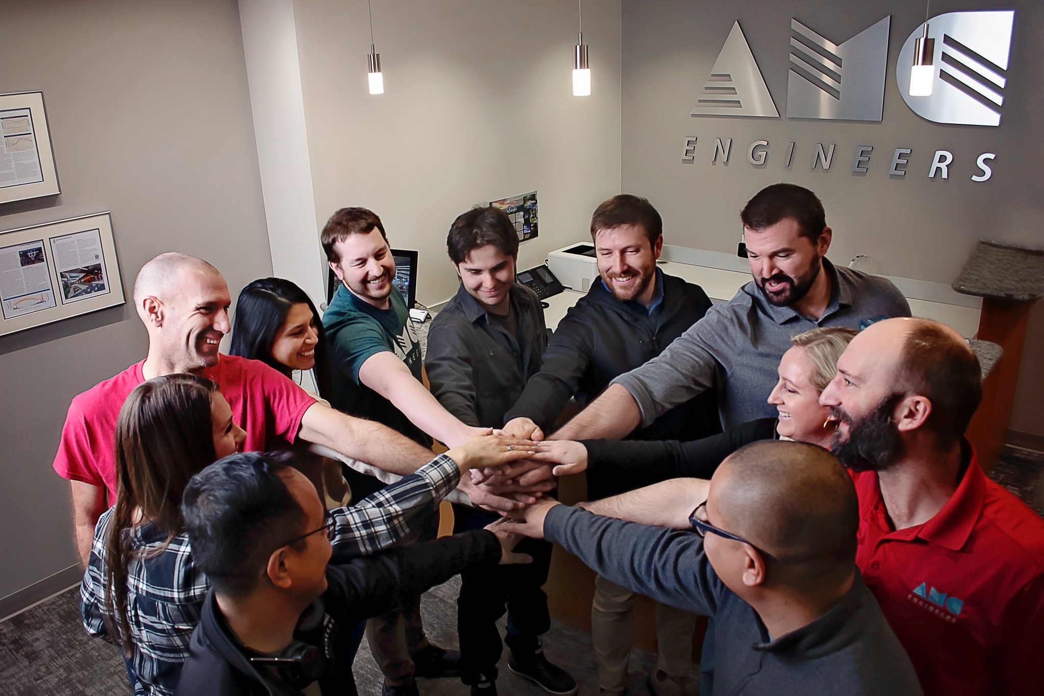 AMC employees putting their hands together in a huddle