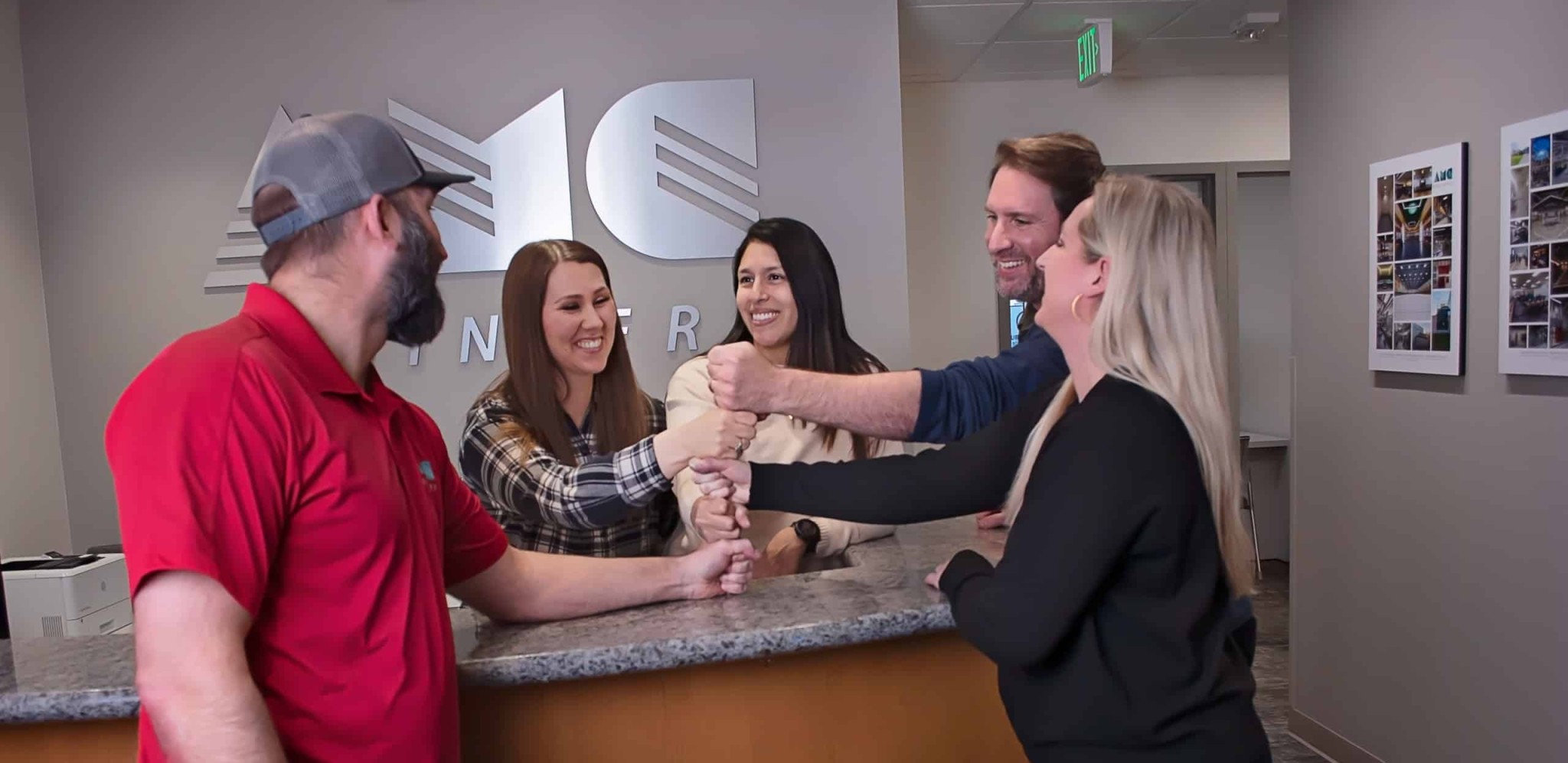 AMC employees putting their hands together in a huddle showcasing their careers