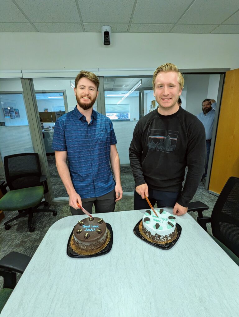 Two men cutting cake